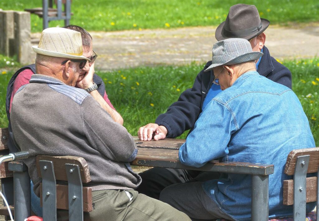Senioren sitzen am Tisch und reden Was ist betreutes Wohnen